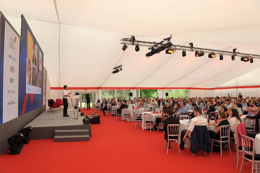 A frame marquee arranged for corporate hospitality with a stage