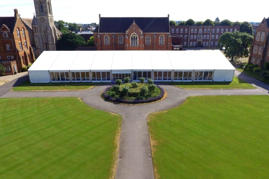Aerial view of a 20m by 50m clear-span frame marquee on a school lawn